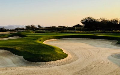 Golf course with sand traps in late afternoon light